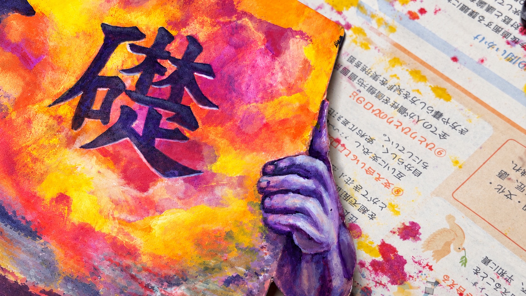 橙色と紫の絵肌、文字と手の造形が見える渡邉帆南美の制作風景をもとにした記事画像